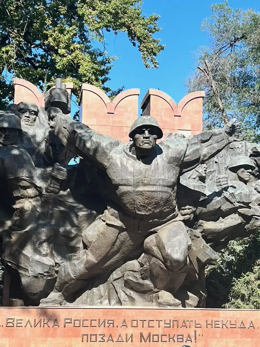 Bronze war memorial statue of soldiers with inscribed text, dedicated to the Panfilov Guardsmen in Almaty